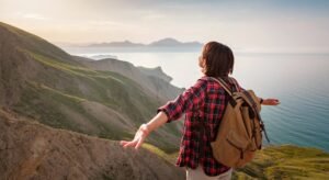 A young Asian woman with a backpack hiking in the summer.