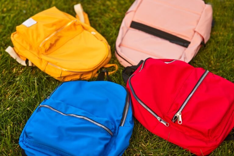 Colorful backpacks placed on grass