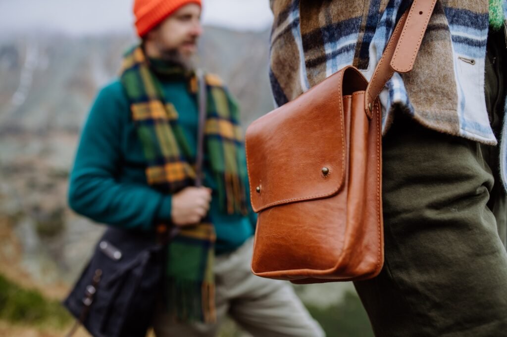 Hikers weraring crossody bags during the hike in an autumn mountains.