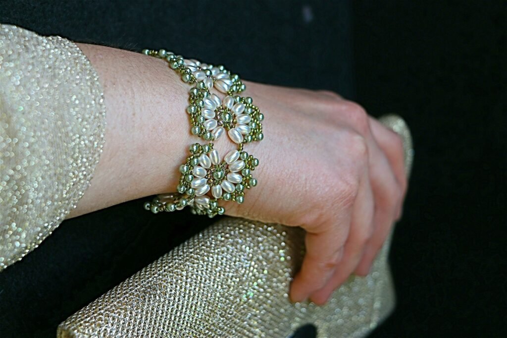 Minimalistic image of woman wearing a beautiful beaded bracelet, carrying an evening bag
