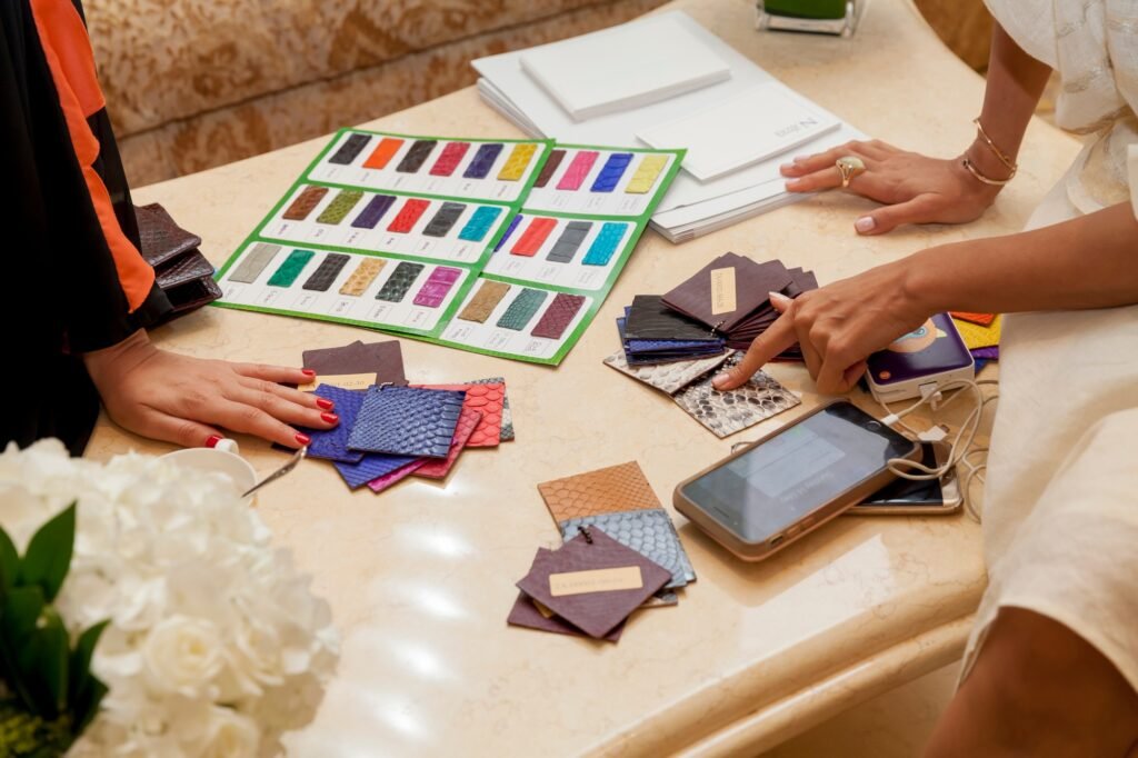 Woman choosing the color for the custom bags. Samples of the leather. Hands in frame.