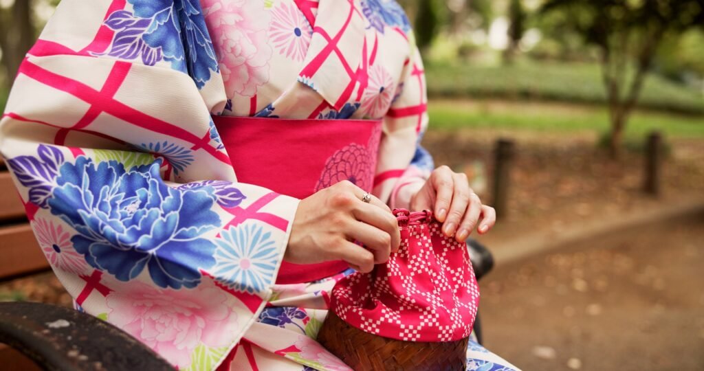 Woman, hands and kimono in park with bag, traditional fashion and relax with indigenous style in Ja