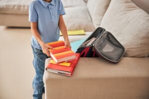 Unrecognisable boy taking books out of a school-bag