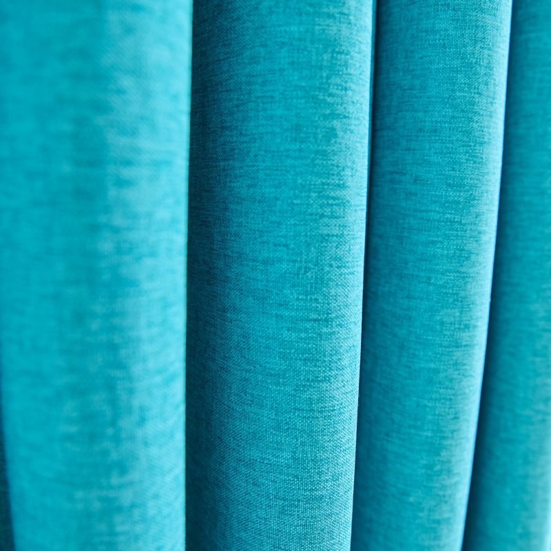 Blue turquoise textured polyester curtains on window, close-up